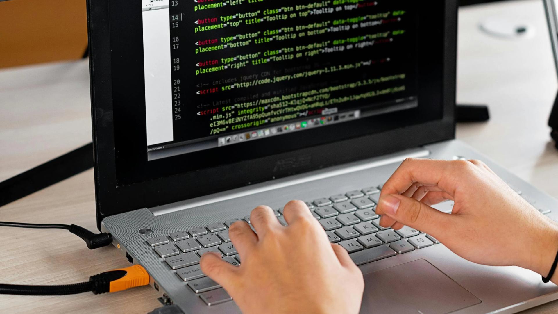 student typing on laptop