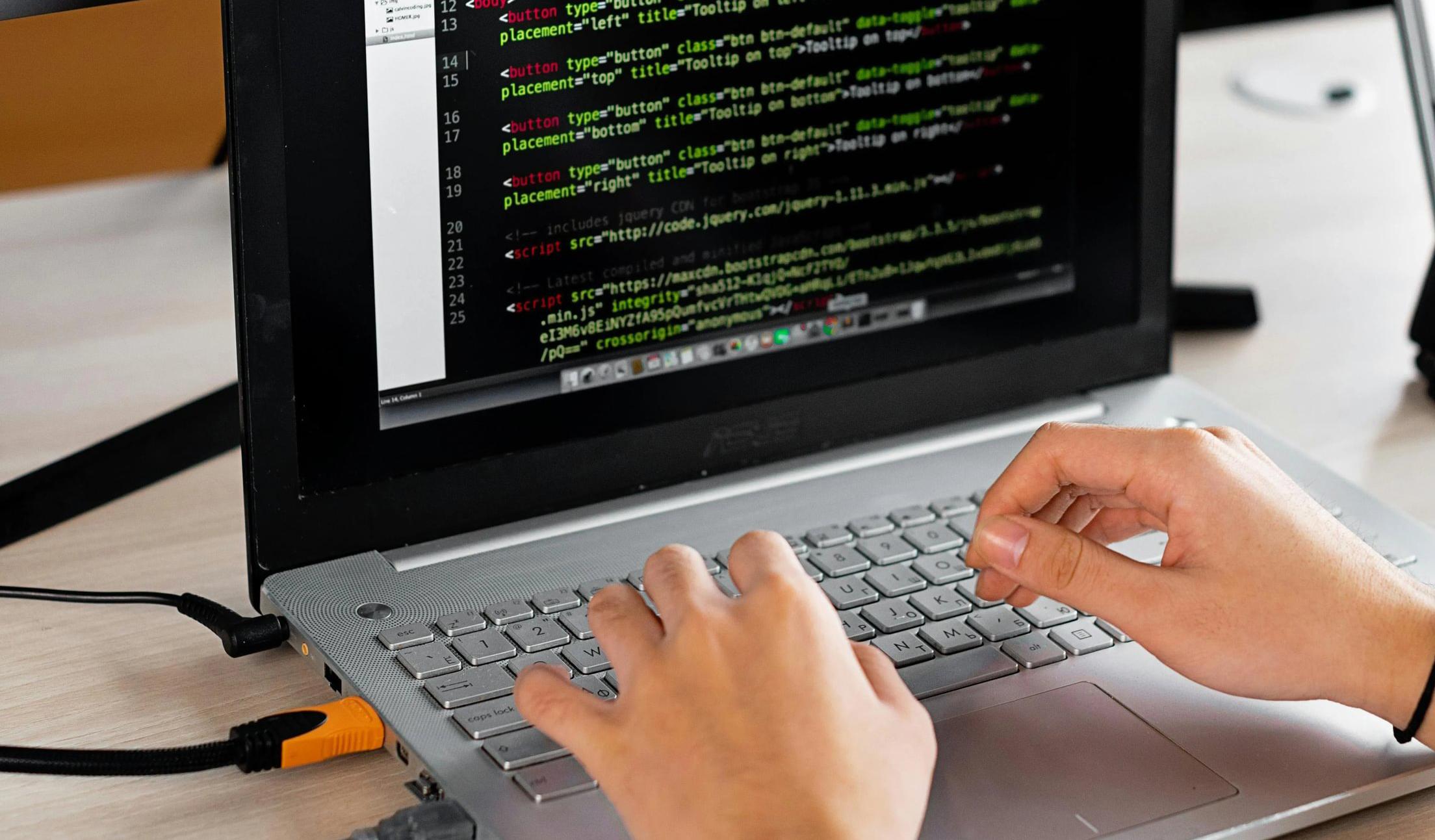 student typing on laptop